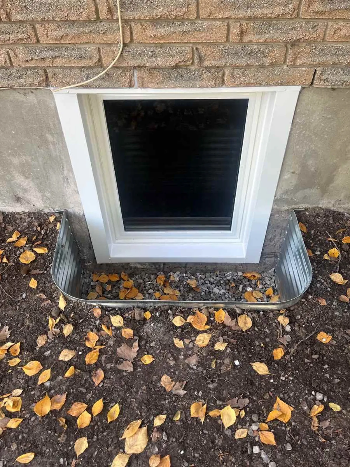 Galvanized steel window well installed around a basement egress window