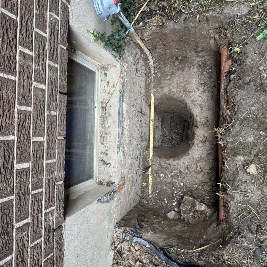 Window well hand dug cleanly beside a marked gas line