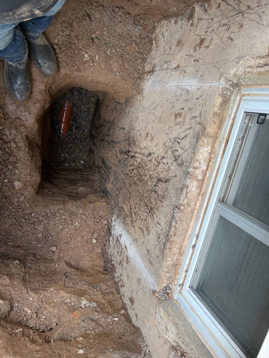 Window well excavation shaft dug down to the weeping tile
