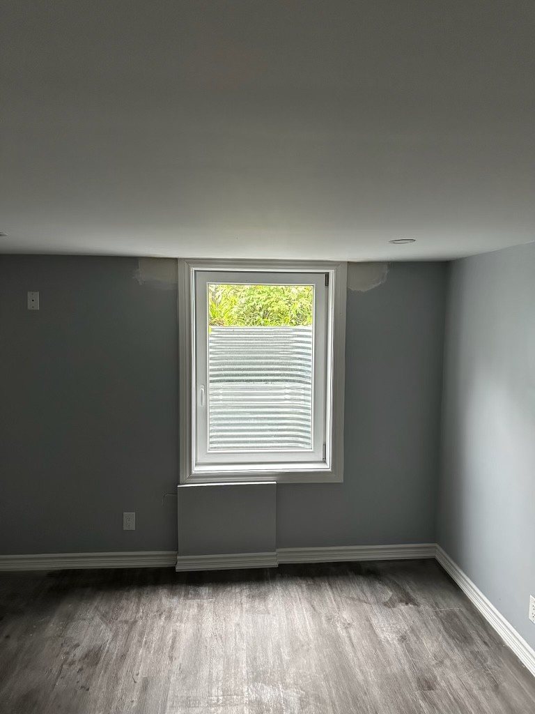 What is an egress window? A finished basement room with daylight coming through a full-size egress window